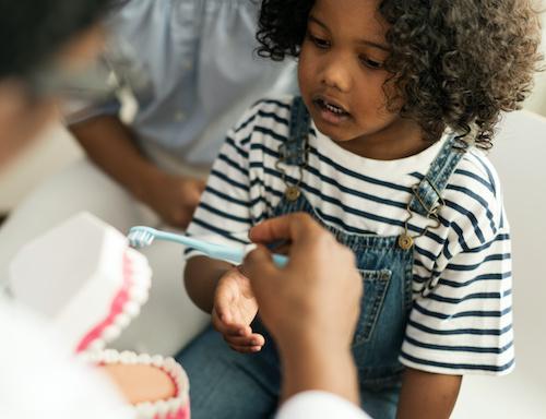 childrens dental exams miami | child learning to brush teeth